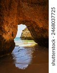 Sea cave at the secluded Beach of the Three Brothers (Praia dos Tres Irmaos) with its towering rock formations and caves at low tide near the coastal town of Alvor on the Algarve coast, Portugal