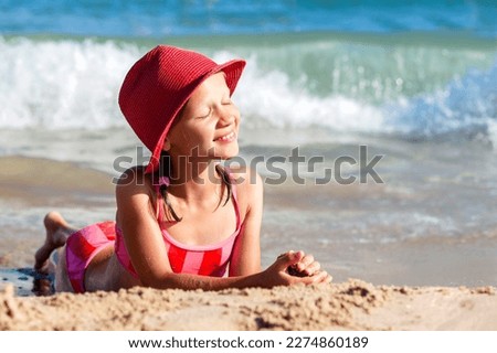 Sea Children Holiday. Beautiful Tann Girl Teen Sunbathing on Sea Sand Beach. Tanned Girl enjoy on Sea Wave Background.