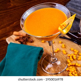 Sea ​​buckthorn Cocktail In Martini Glass On Wooden Table. Close Up