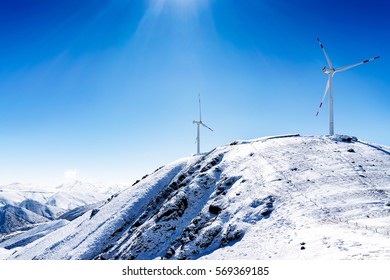 Sea dials high, snowy mountains, Wind turbine production of green energy - Powered by Shutterstock