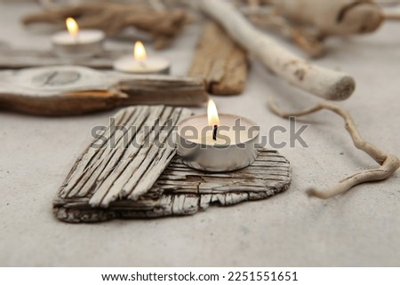 Sea driftwood pieces and tea light candles on stone background. Pieces of sea drift wood. Bleached dry aged drift wood. 