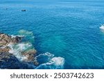 Sea foam and Atlantic Ocean waves crashing against the rocks in Los Gigantes Tenerife Spain