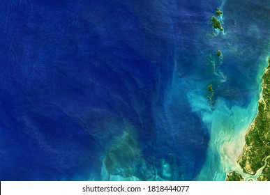 Sea in global satellite photo, aerial top view of blue ocean. Detailed Earth surface taken from space, tropical coastal waters for nature texture background. Elements of this image furnished by NASA.