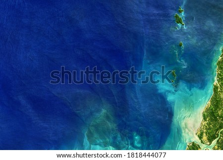 Sea in global satellite photo, aerial top view of blue ocean. Detailed Earth surface taken from space, tropical coastal waters for nature texture background. Elements of this image furnished by NASA.