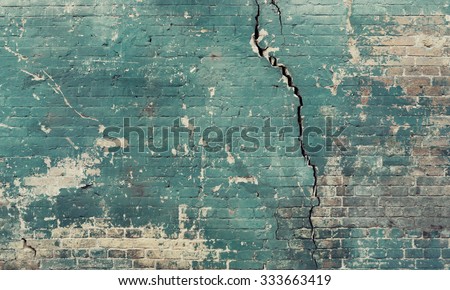 Sea green broken cracked brick wall.