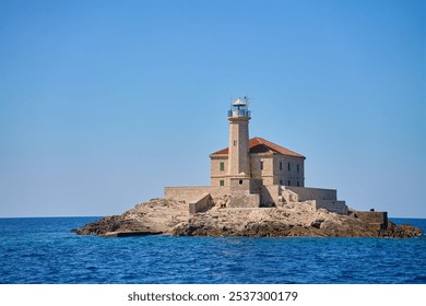 Sea landscape with lighthouse on tall rocky island in sea on sunny day - Powered by Shutterstock