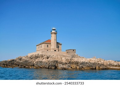 Sea landscape with lighthouse on tall rocky island in sea on sunny day - Powered by Shutterstock