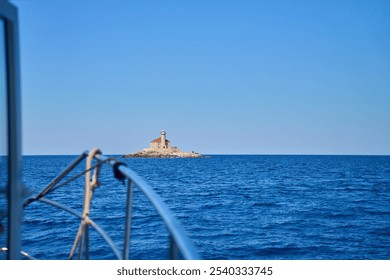 Sea landscape with lighthouse on tall rocky island in sea on sunny day - Powered by Shutterstock