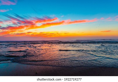 Sea landscape on sunset or sunrise with ocean waves and orange colorful clouds in sky. Concept of vacation on beach, free time, travel, summer, disconnecting from routine and relaxing.
