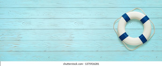 Sea lifebuoy on blue wooden background . Copy space for individual text.  Summer Banner.