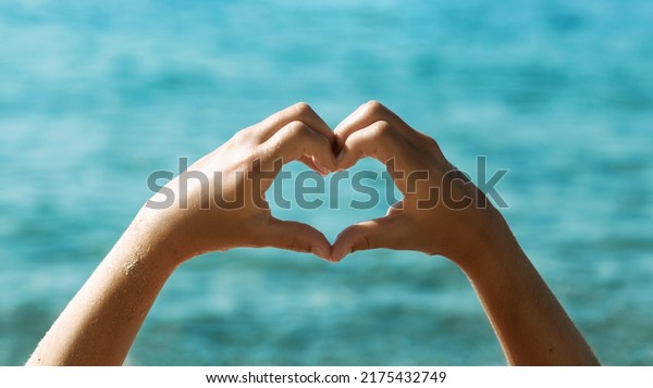 Sea Love Heart by Hands on Sea background. Summer\
Sea Holiday concept