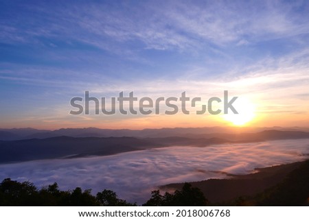 Sea of mist scenary at sunrise time. Beautiful blue sky with cloud. Silhouette mountains.
