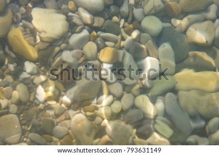 sea pebble beach with multicoloured stones, waves with foam