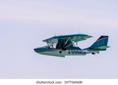 A sea plane flies above Miramar Beach in Florida on May 1, 2021 with space for copy within the image.
