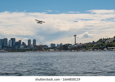 Sea Plane Flying Over Lake Union With The Seattle Skyline In The Background