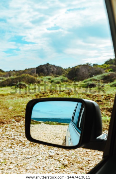 sea reflection in car rear mirror. road trip.\
summer vacation