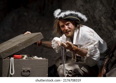 Sea robber captain of pirate ship armed with treasure chest in cave. Concept historical halloween. Filibuster cosplay. - Powered by Shutterstock