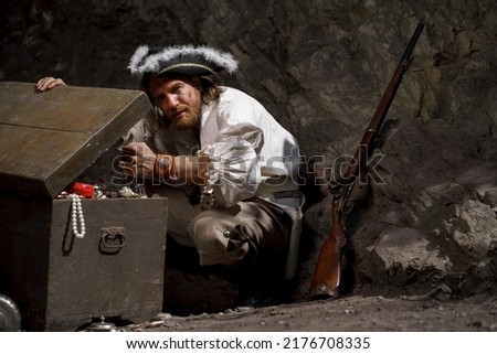 Sea robber captain of pirate ship armed with treasure chest in cave. Concept historical halloween. Filibuster cosplay. ストックフォト © 
