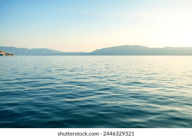 The sea with a rocky shore on the background of a blue sky - Powered by Shutterstock