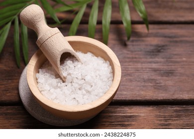 Sea salt in bowl and green leaves on wooden table, space for text. Spa product - Powered by Shutterstock