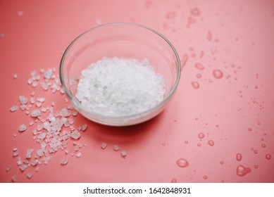 Sea Salt In A Glass Bowl On A Pink Pastel Background Next To Sea Water