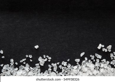 Sea Salt Grains On The Black Background.