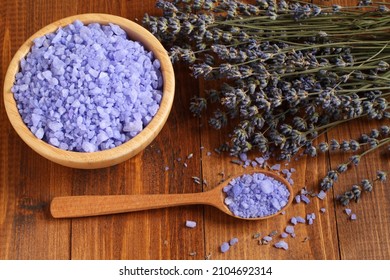 Sea Salt With Lavender In A Bamboo Bowl And In A Wooden Spoon And Dried Lavender Flowers Are Located On A Brown Wooden Table. Closeup. Top Down View.