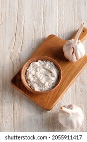 Sea Salt In Wooden Saucer With Garlic Cloves, Selective Focus, Shallow Depth Of Field. Kitchen Table Concept. Warm Tone