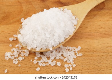 Sea salt in wooden spoon close up