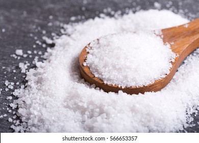 Sea Salt In A Wooden Spoon On Dark Table.