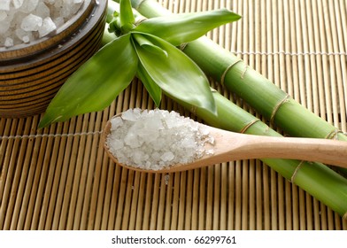 sea salts in wooden bowl with bamboo on mat - Powered by Shutterstock