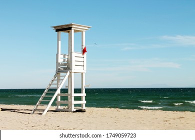Sea sandy beach and white wooden tower (rescue post) in Evpatoriya, Crimea.