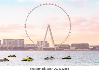 Sea Scooters And Aquabikes As Water Sports Attractions Waiting For Vacationers Against The Backdrop Of The Famous Ferris Wheel Dubai Ain