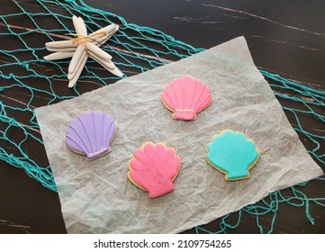 Sea Shell Sugar Cookies With Royal Icing On Ocean Theme Background.