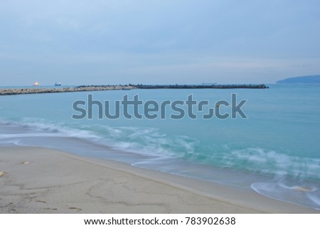 Sea shore in the evening, waves with large stones