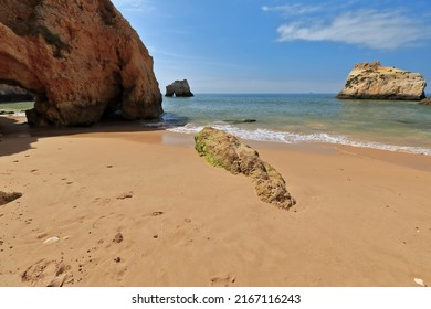Sea stacks and cliffs at the central-east part of Praia da Prainha Beach with natural caves and holes sculpted by the force of the sea waves at the foot of the cliff. Alvor Portimao-Algarve-Portugal.