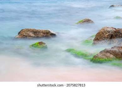 Sea stones in the water of the Mediterranean Sea. Water creates fog due to long exposure.