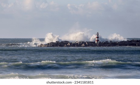 Sea storm in a sunny day seeing strong waves against pier and beacon of Povoa de Varzim harbor and marina entry. North of Portugal. - Powered by Shutterstock