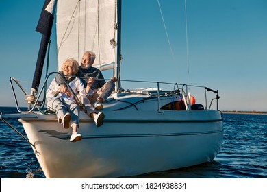 Sea Trip. Happy Beautiful Senior Family Couple Hugging And Having Fun While Relaxing On A Sail Boat Or Yacht Deck Floating In A Calm Blue Sea, They Enjoying Amazing Sunset