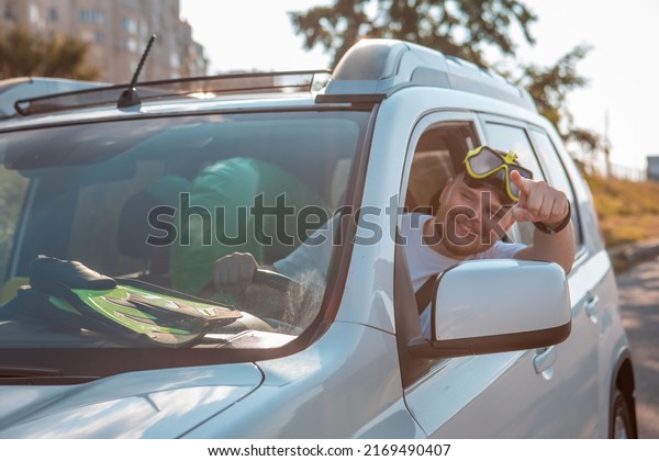sea vacation car travel concept happy man in\
scuba mask driving car full of\
bags