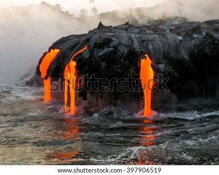 Sea view of Kilauea Volcano in Big Island, Hawaii, United States. A restless volcano that has been in business since 1983. Shot taken at sunset when the lava glows in the dark as jumps into the sea.