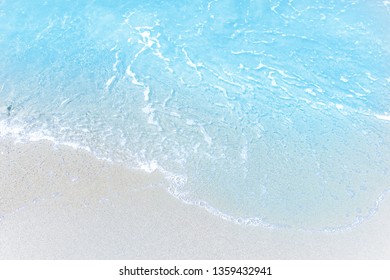 Sea wave and bubble on a sandy white beach blue sea background texture and copy space  holiday concept 