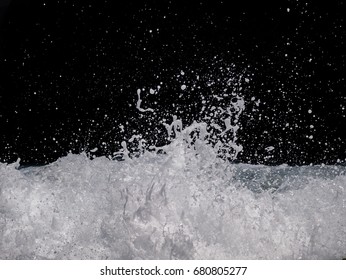 The Sea Wave Crashing On The Rock And Make The Splashing Water And White Air Foam Bubble. Isolated On Black Background With Clipping Path.