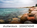 Sea wave crashing on yellow rocks in a summer day