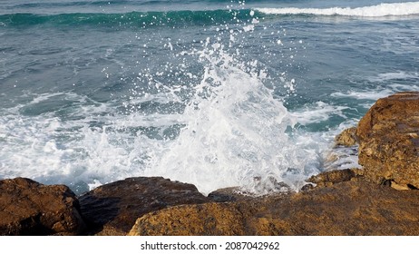 sea wave hits coastal stones