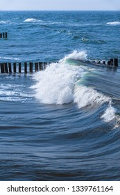 Sea Wave Splashing When Overrun And Hit Row Of Wooden Groin (copy Space)