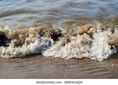 Sea wave with spray and foam near the shore. High quality photo