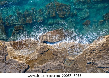 Sea waves breaking on rocky shore, aerial natural background