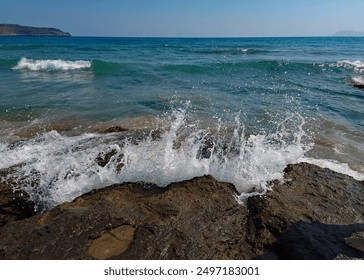 Sea waves crashing on the rocky shore at the resort of Agia Marina on the Greek island of Crete in Europe. - Powered by Shutterstock