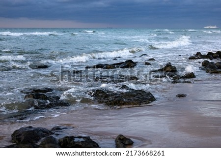Sea waves hitting rocks on the beach with turquoise sea water causing water splashes. Amazing rock cliff seascape in the French opal coastline. . High quality photo